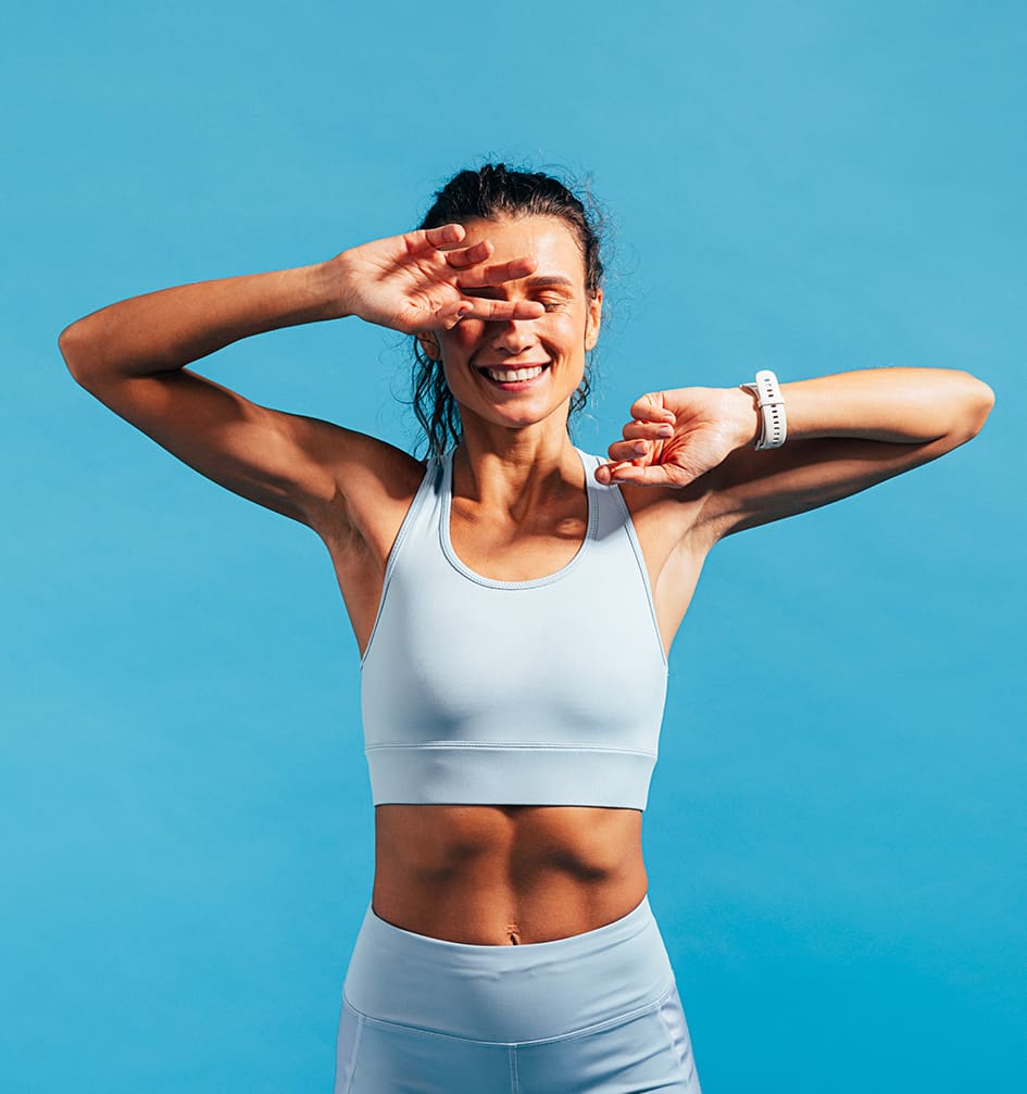 Femme souriante en sous-vêtements blancs posant avec confiance. Découvrez des conseils pour prendre soin de votre peau avec des routines skincare naturelles et des compléments alimentaires pour une beauté durable