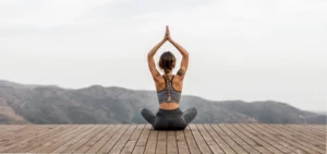 femme pratiquant le yoga en extérieur pour réduire le stress et protéger son vieillissement biologique