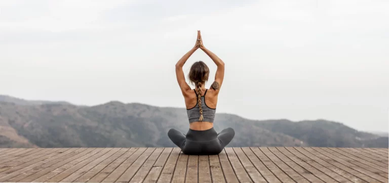 femme pratiquant le yoga en extérieur pour réduire le stress et protéger son vieillissement biologique