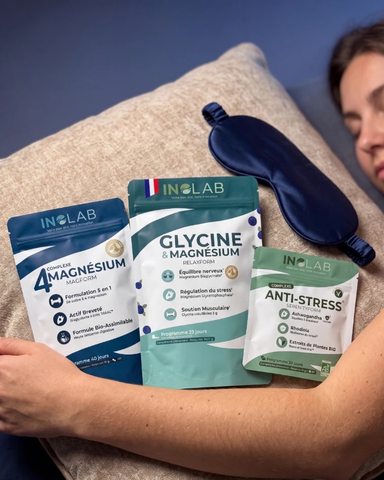 Femme tenant le pack sommeil anti-stress Inolab près d'un oreiller avec masque de nuit, glycine magnésium et ashwagandha bio pour favoriser l'endormissement