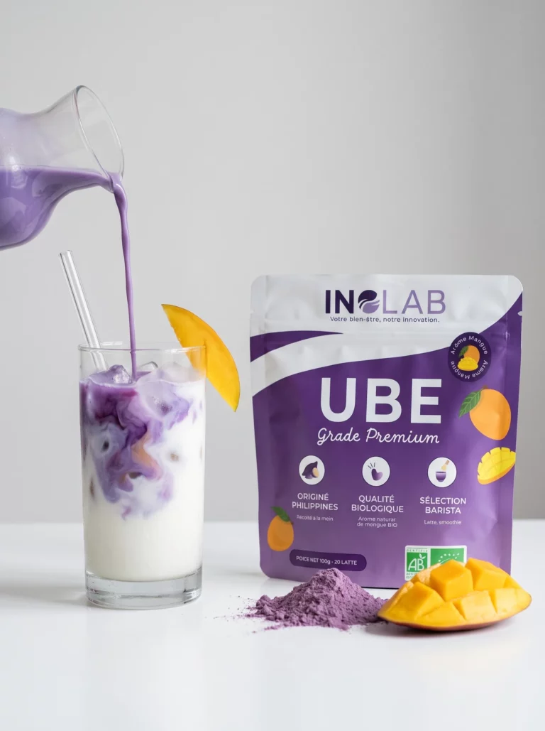 Lait d'ube violet versé dans un verre avec une tranche de mangue, pochon d'Ube Mangue Inolab derrière