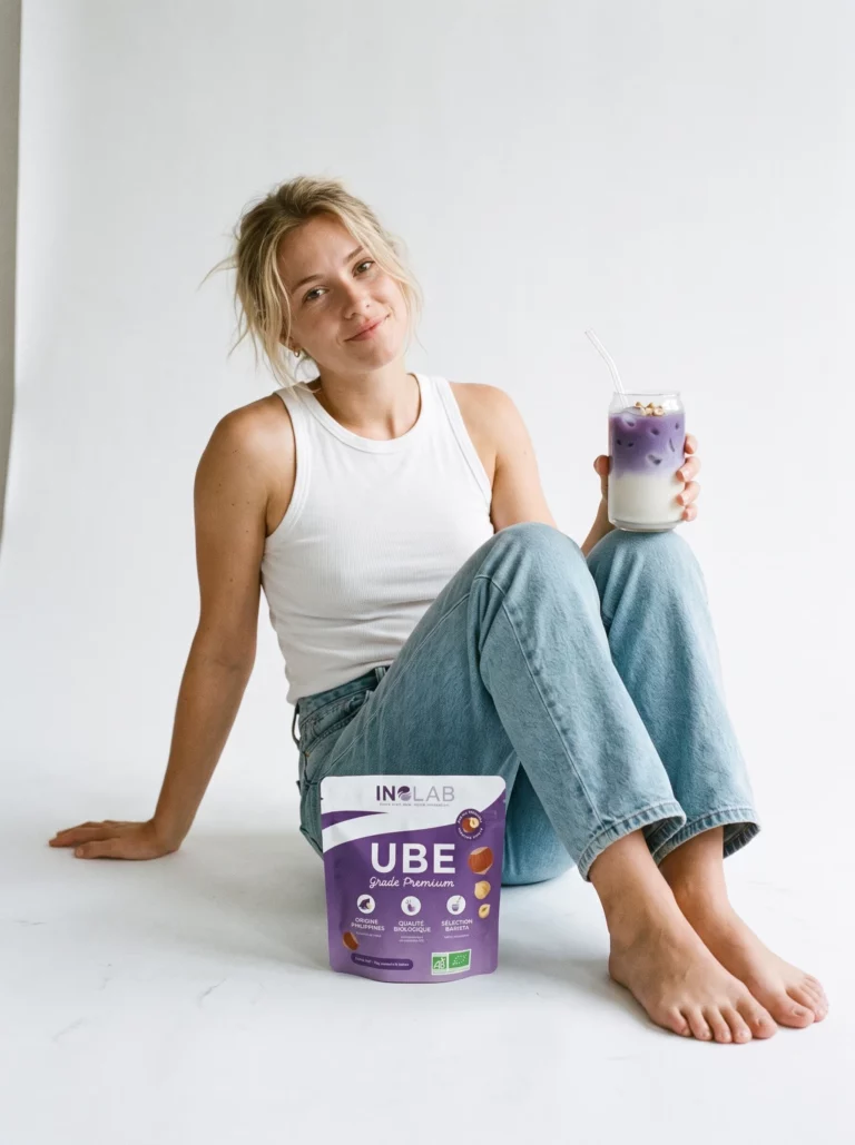 Femme souriante mangeant un pancake à l'ube et aux noisettes avec un pochon d'Ube Noisette Inolab
