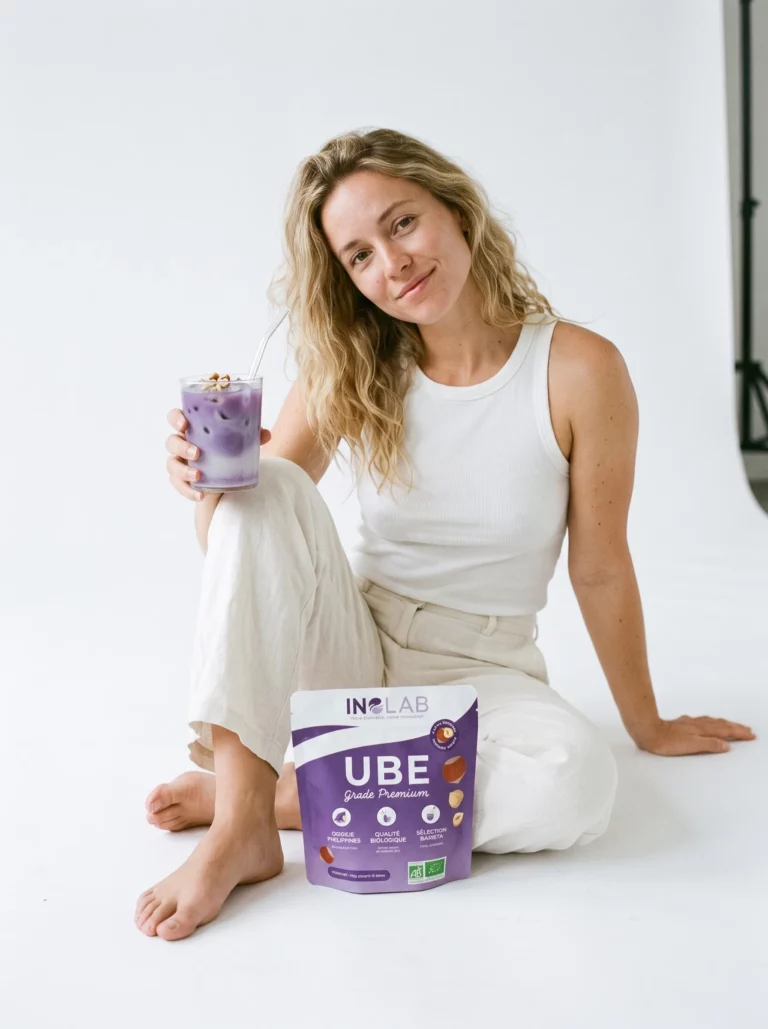 Femme souriante mangeant un pancake à l'ube et aux noisettes avec un pochon d'Ube Noisette Inolab