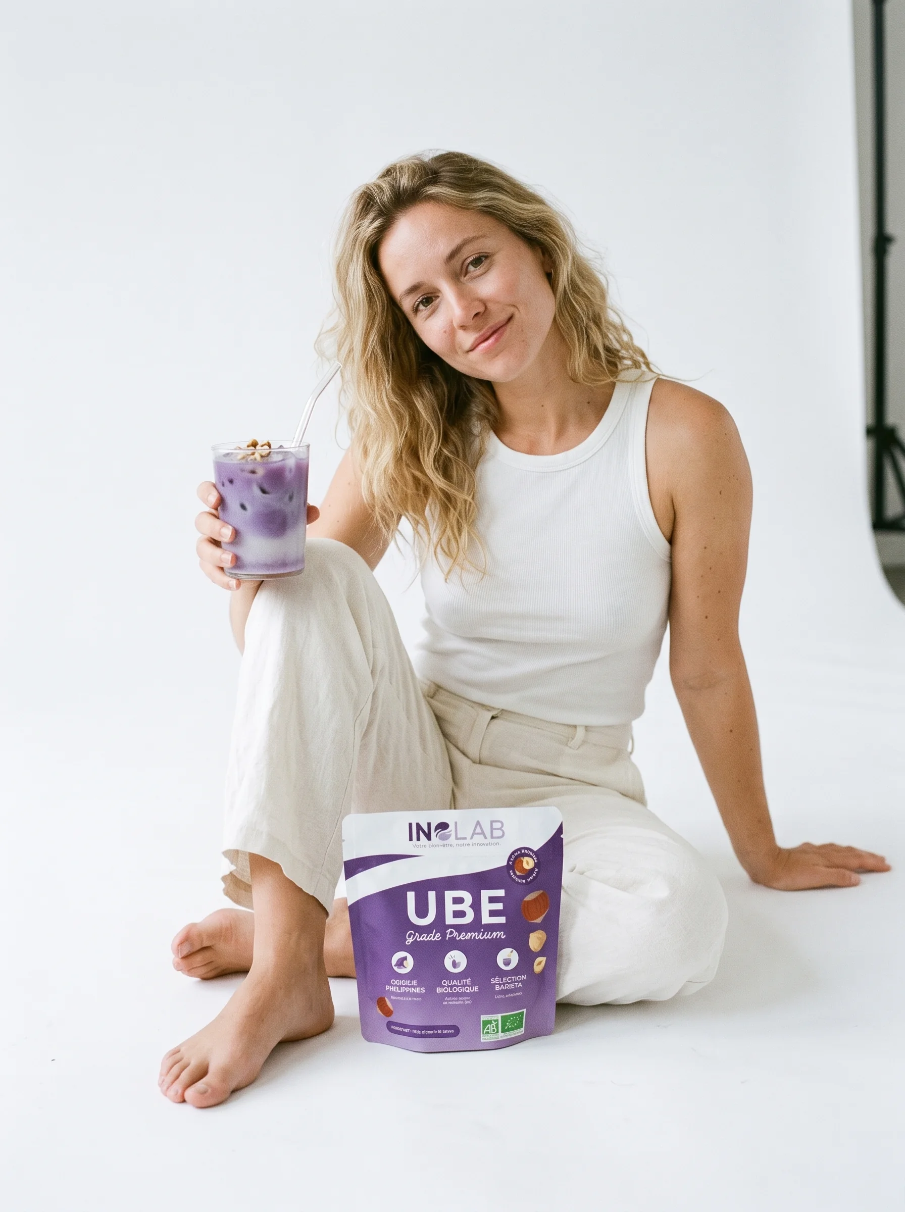 Femme souriante mangeant un pancake à l'ube et aux noisettes avec un pochon d'Ube Noisette Inolab