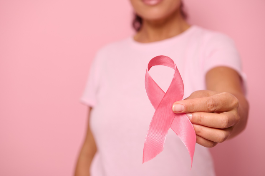 Femme tenant un ruban rose symbole d'Octobre Rose, illustrant la sensibilisation au cancer du sein et les enjeux de santé féminine après 40 ans